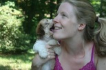 sable and white havanese puppies giving kisses to girls
